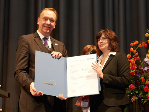 Das Bild zeigt die Übergabe des Zertifikats durch die Auditteamleiterin Christine Flöter (TÜV NORD) an den Präsidenten Dr. Helmut Tschiersky am 31.10.2012 anlässlich der 10-jährigen Jubiläumsfeier des BVL .